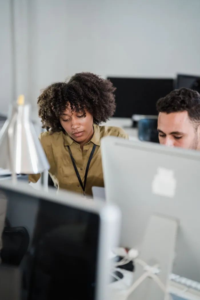Two colleagues working together at computer screens